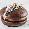 Black Forest Gateau Whoopie Pie with chocolate cheesecake filling and dark cherry compote centre, topped with Belgian white chocolate and edible petals