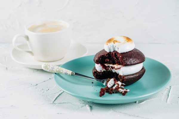 Classic Chocolate & Toasted Marshmallow Whoopie on a plate with a cup of coffee