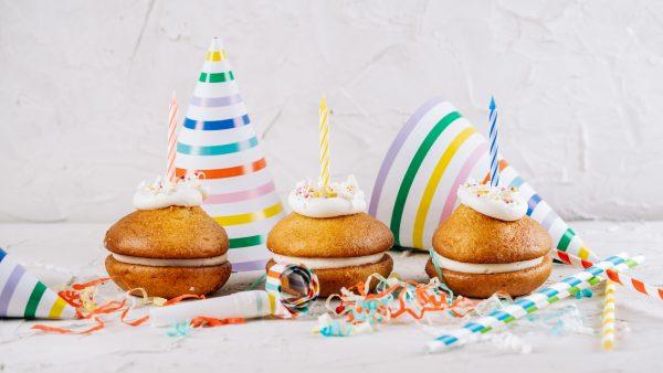 Three Birthday cake Whoopie Pies with candles, streamers and colourful hats